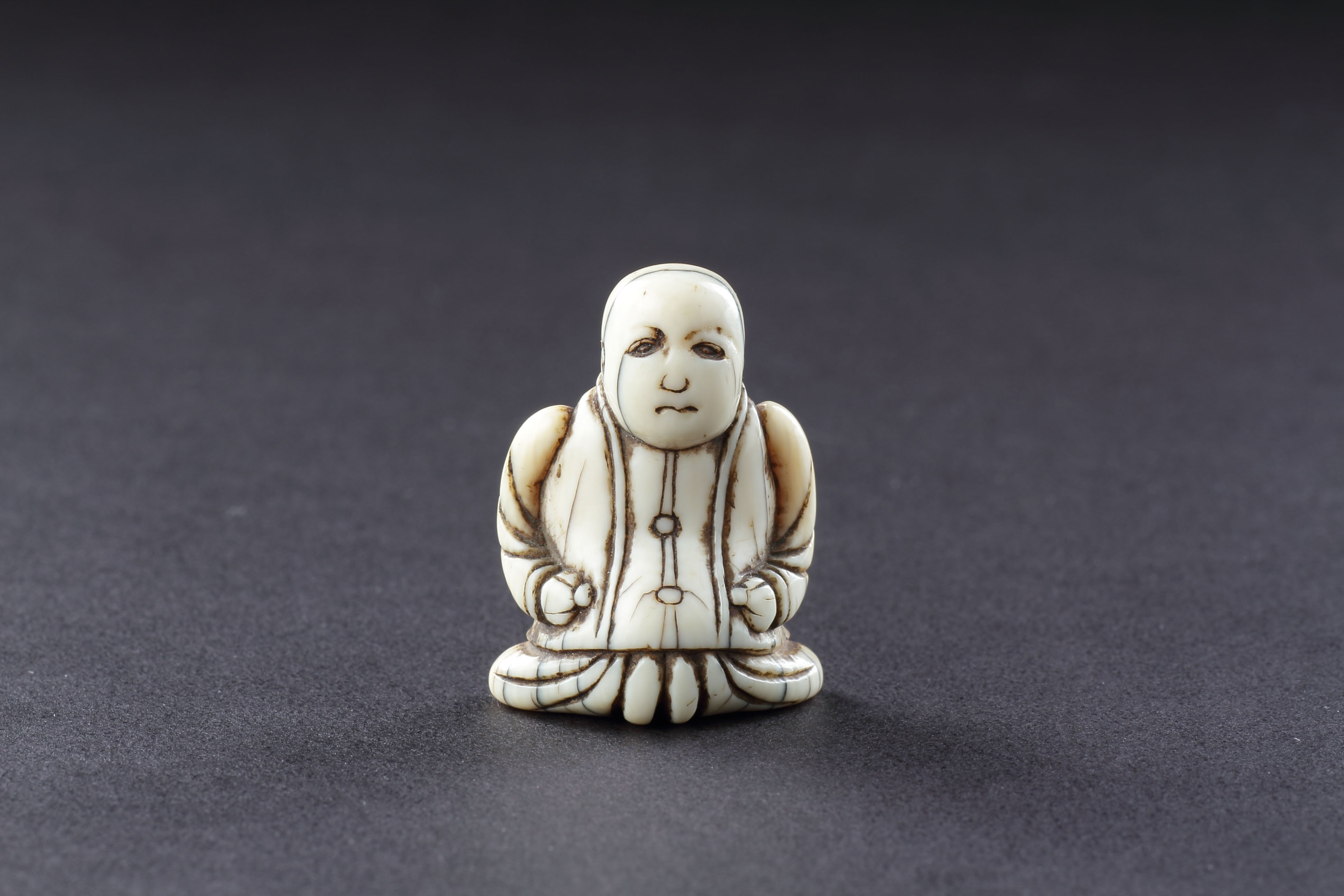 Japanese Ivory Netsuke of a Dutch Merchant Kneeling in his Buttoned Coat and Baggy Trousers